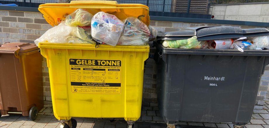 Müllcontainer Drei volle Müllcontainer, die in einer Reihe stehen.