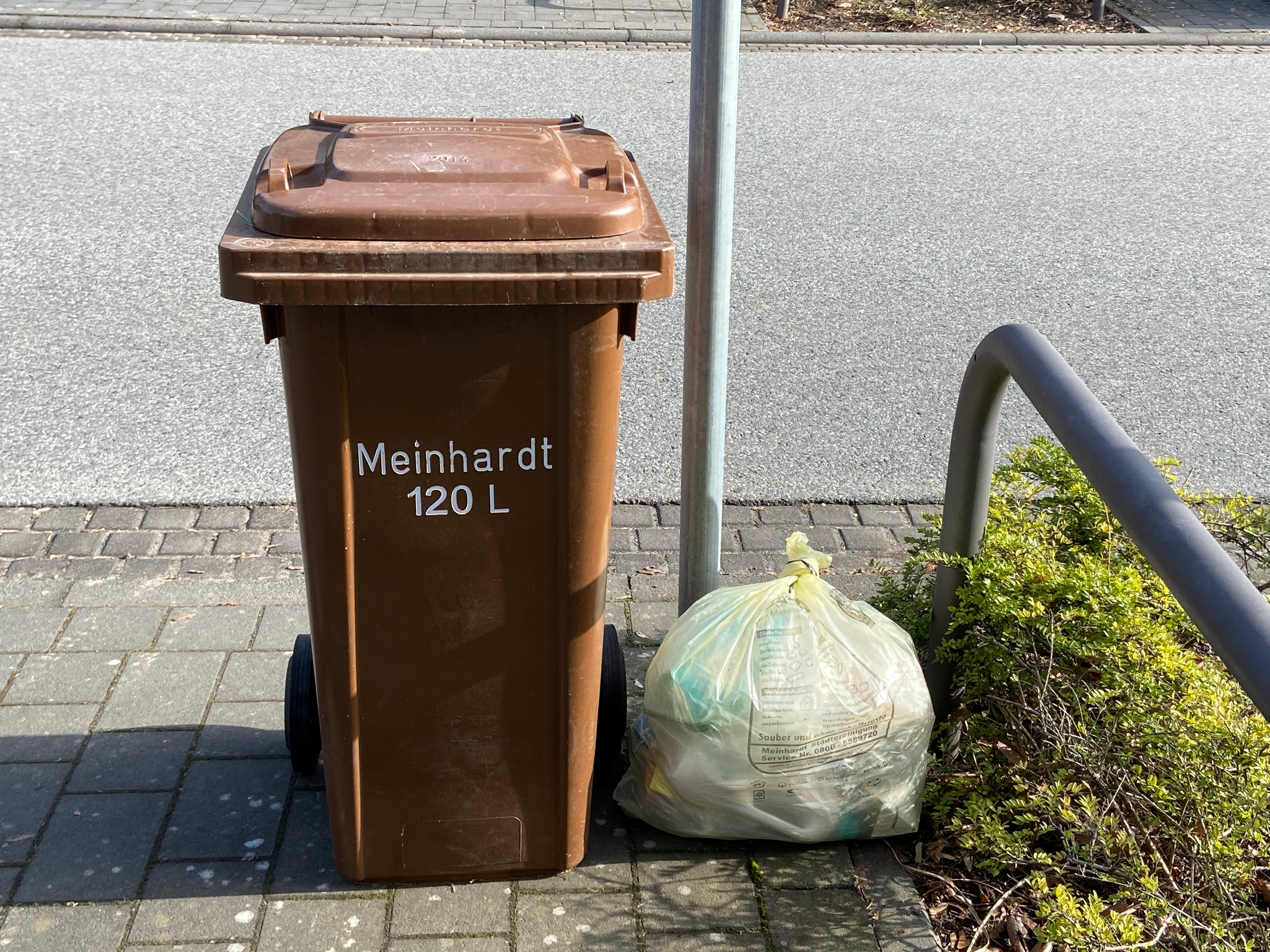 Mülltonne Links steht eine Mülltonne und rechts ein Müllsack