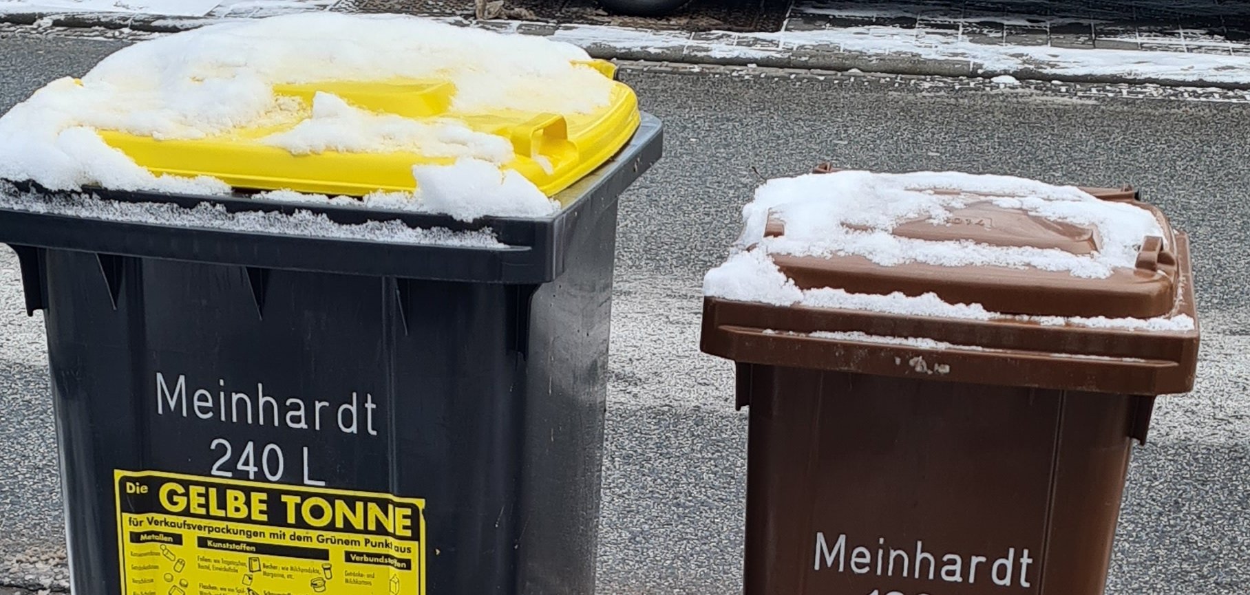 Mülltonnen Zwei Mülltonnen, die im Schnee stehen.