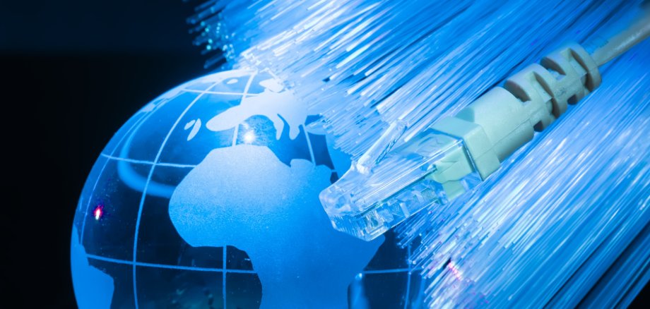 Die Erde als blaue durchsichtige Kugel, mi einem LAN Stecker darauf.