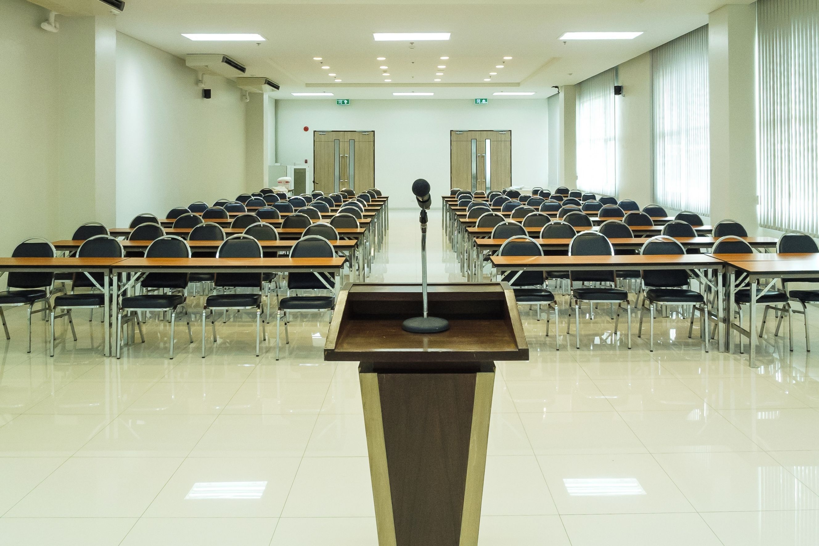 Ein Podest, in einem Sitzungssaal mit vielen Stühlen.