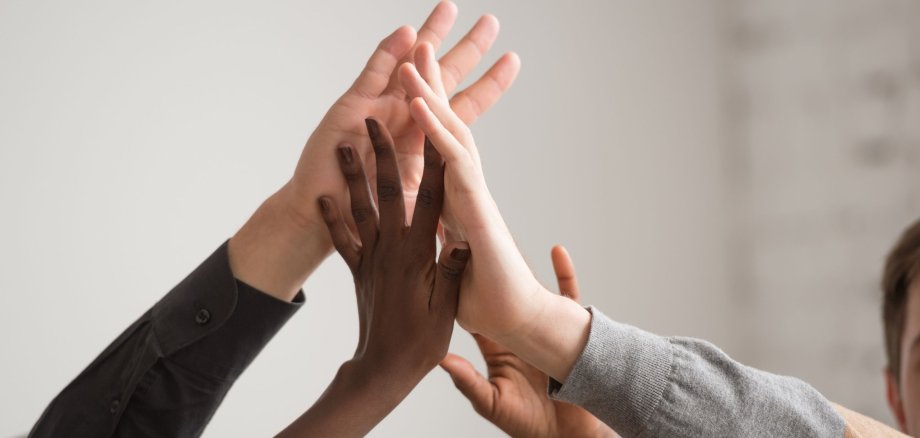 Verschiedene und mehrere Hände, die in einander schlagen.