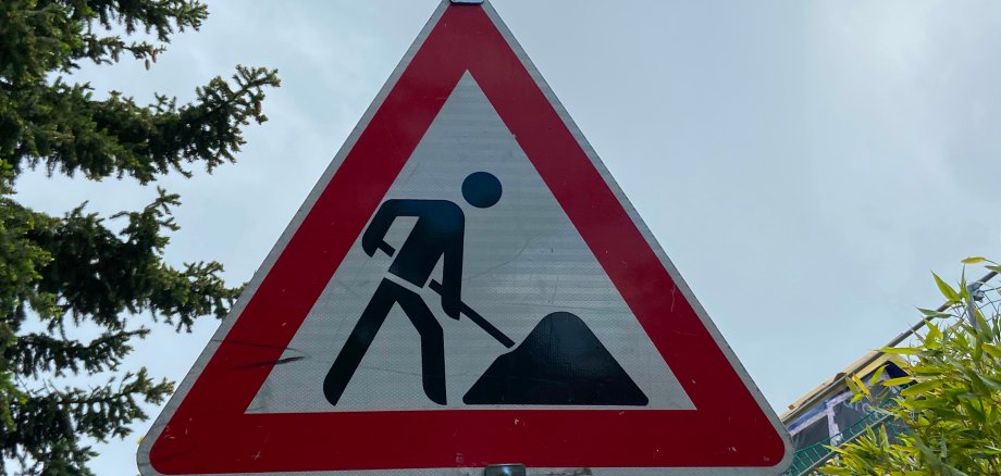 Straßenschild, auf welchem ein Straßenarbeiter bei seiner Arbeit zu sehen ist