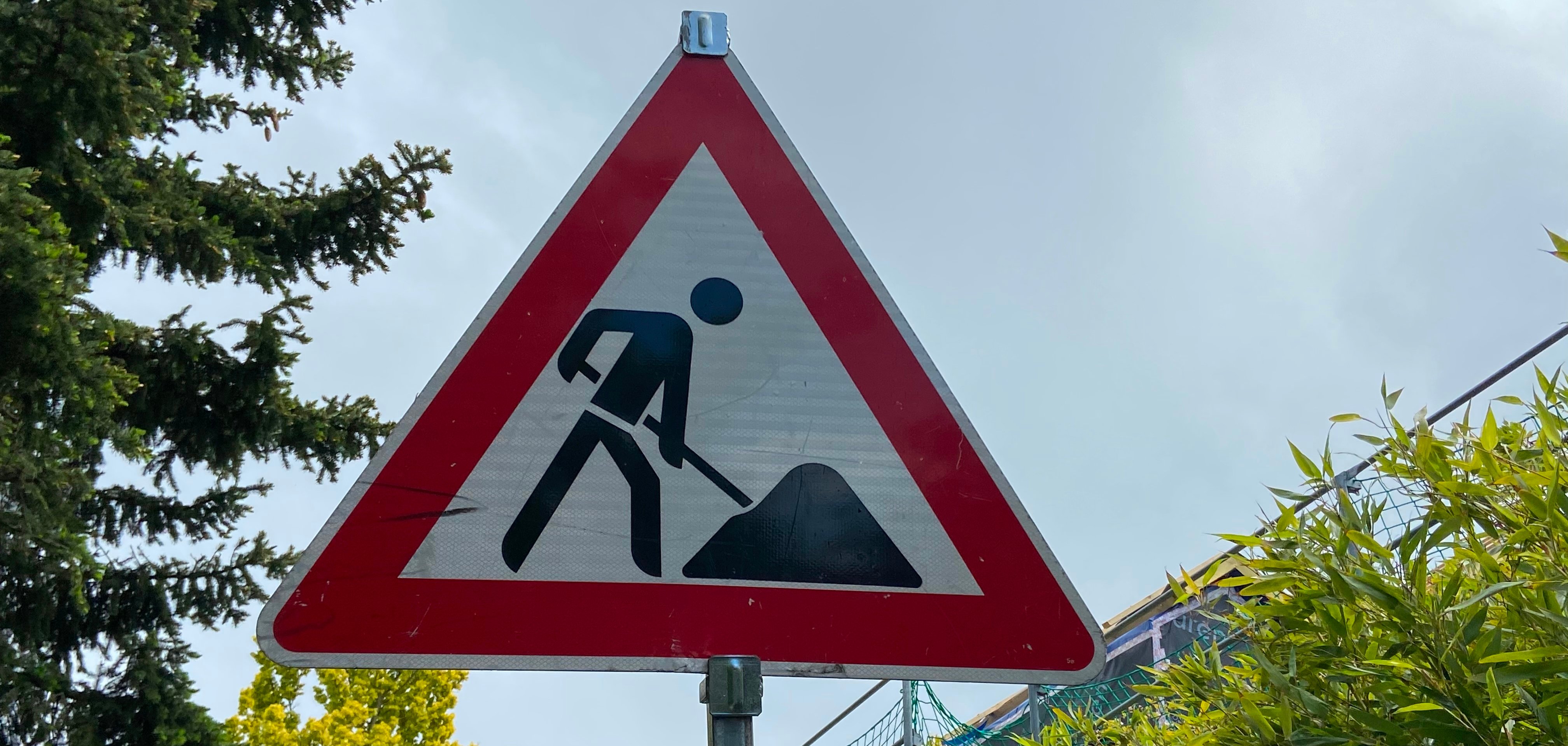 Straßenschild Ein Straßenschild auf dem ein Bauarbeiter arbeitet