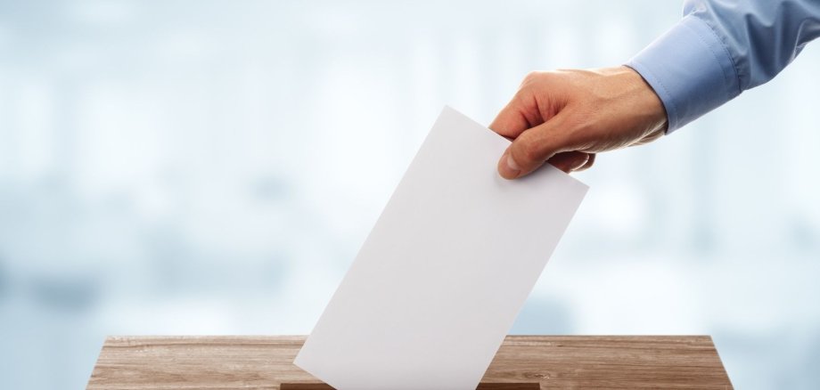 Wahlbrief wird in Wahlurne geworfen