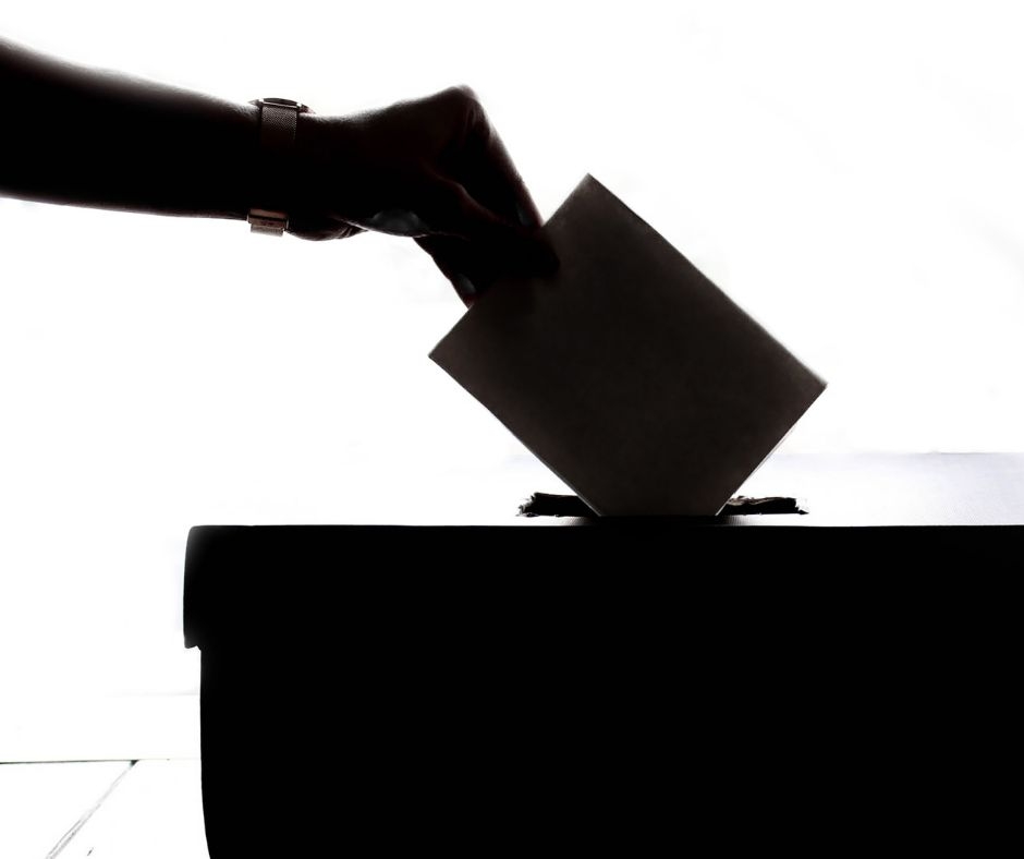Briefwahl Brief wird in Wahlurne geworfen