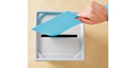Hand wirft Stimmzettel in Wahlurne Hand wirft Stimmzettel in Wahlurne
