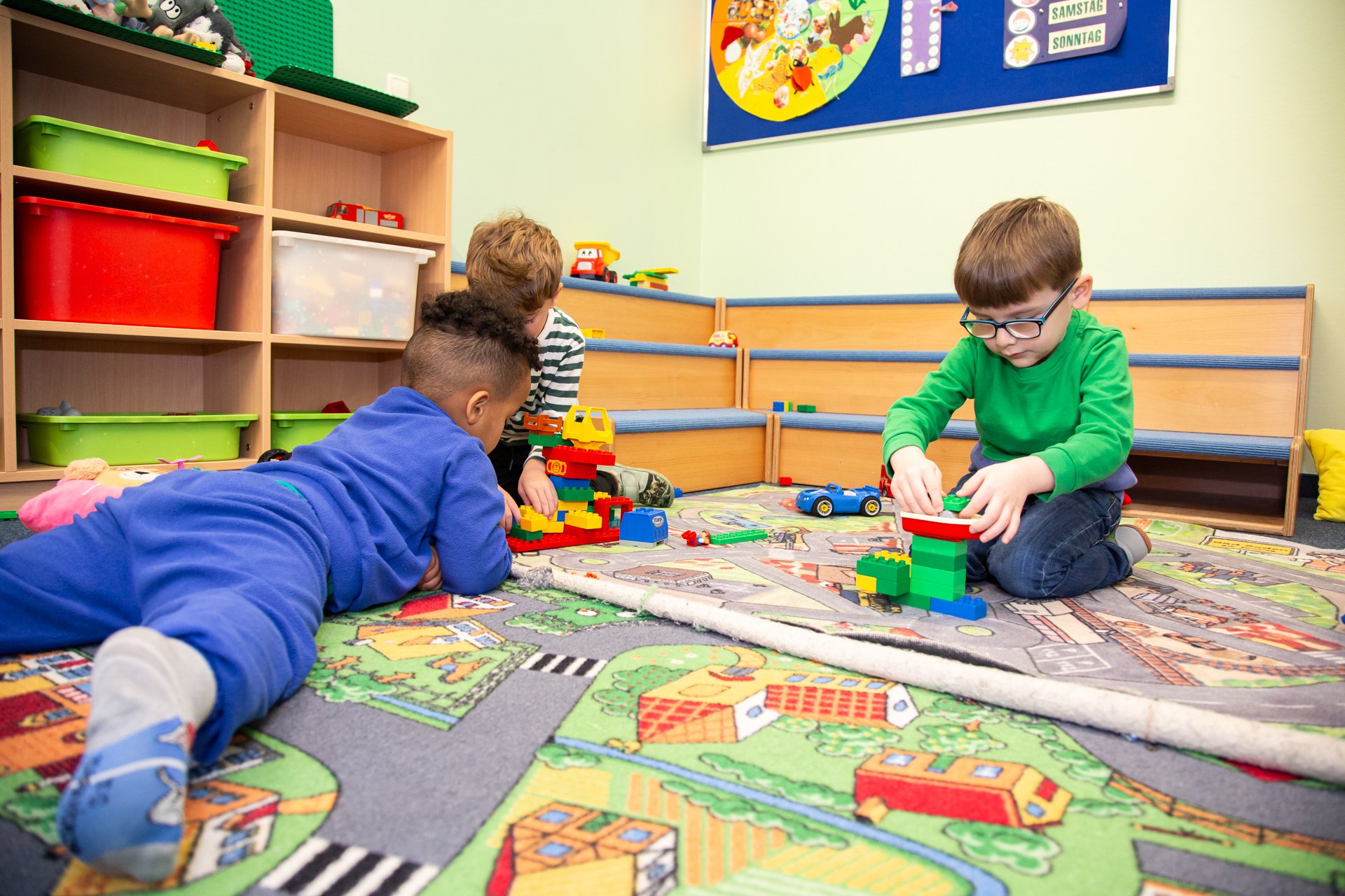 Spielteppich Das Bild zeigt Kinder auf ihrem Spielteppich