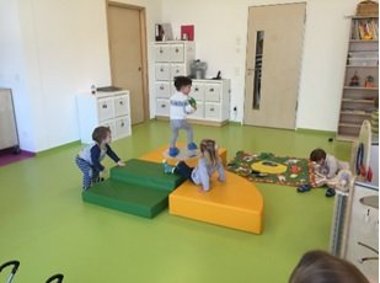 Kinder spielen auf großen Bauklötzen