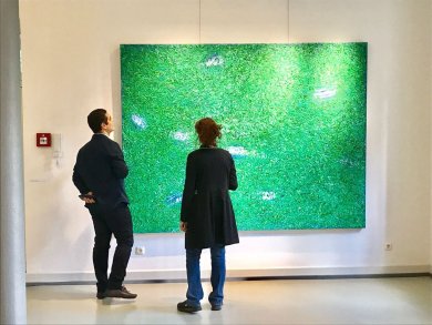 Kunstausstellung Besucher in der Stadtgalerie schauen sich ein Gemälde an.