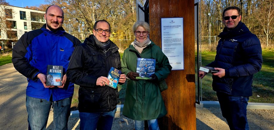(v.l.n.r.) Chris Becker, Leiter der Stadtbücherei, Bürgermeister Dr. Frank Blasch, Bestsellerautorin Nele Neuhaus und Florian Bienias von der Süwag sorgten für die erste Befüllung des Bücherschrankes am Bundesweiten Vorlesetag.   