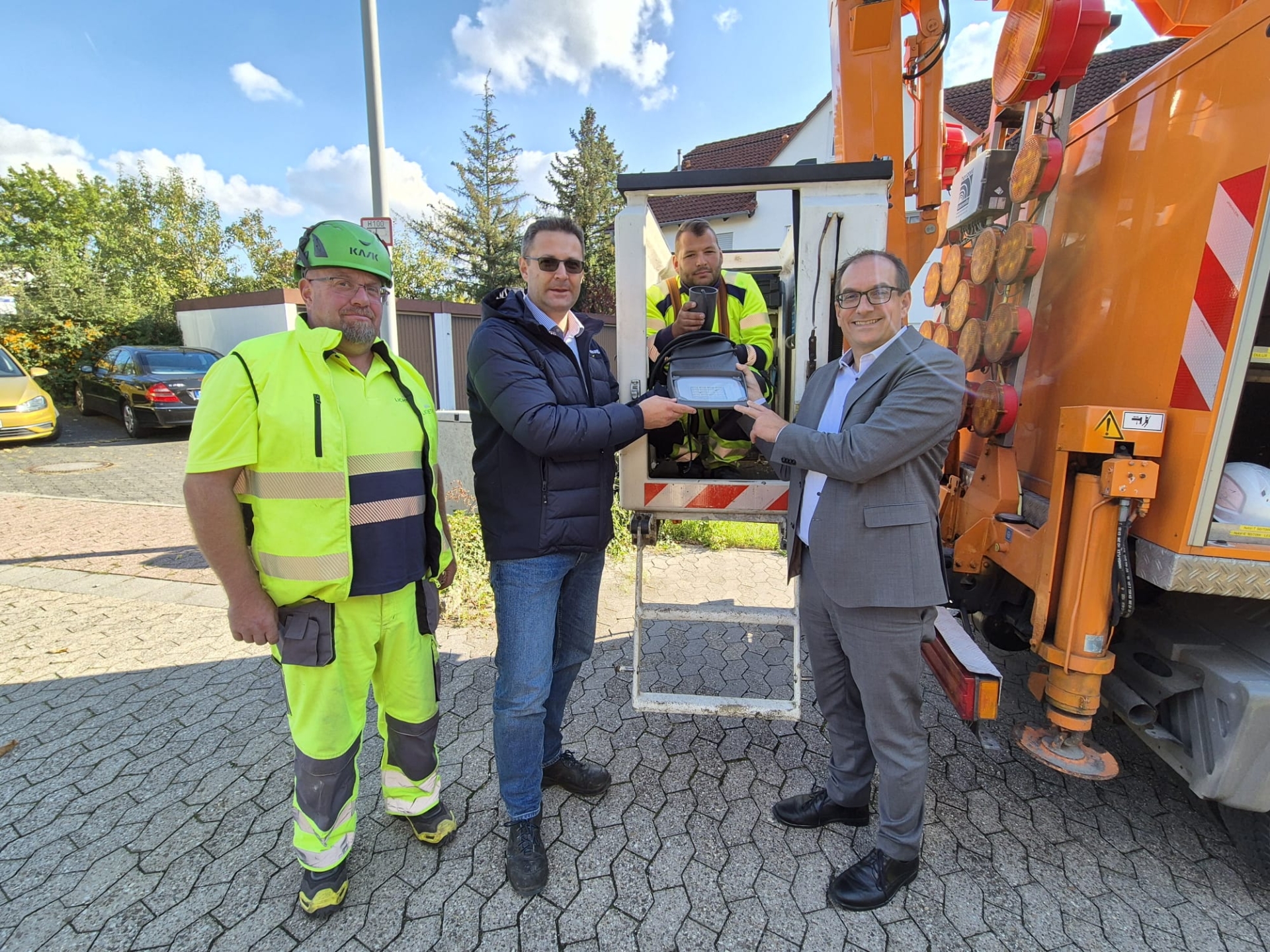 LED-Umrüstung Timo Knöß (l.) und sein Kollege Benedikt Manny von der Firma Lichtbetrieb aus Essen mit Florian Bienias (2.v.l.) und Bürgermeister Dr. Frank Blasch (r.) bei der Installation einer LED-Leuchte in der Eifelstraße.