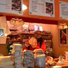 Ein Wochenmarktverkäufer mit einem Brot in den Händen
