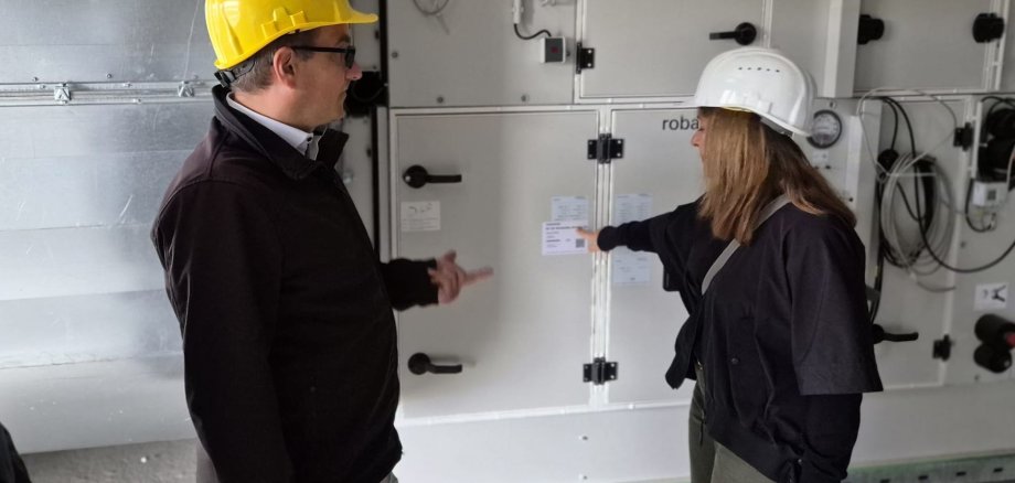 In der Technikzentrale sind die Lüftungsanlagen bereits montiert. Projektleiterin Corina Kaiser bei einem Rundgang durchs Gebäude mit Bürgermeister Dr. Frank Blasch. Foto: Stadt Bad Soden am Taunus
