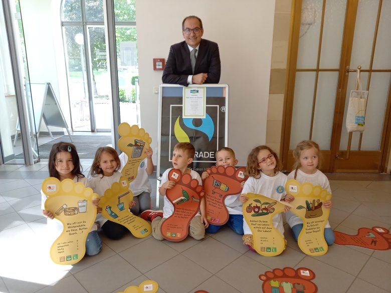 Bürgermeister Dr. Frank Blasch und Kinder der "Fairen Kita" Sonneburg mit der Urkunde zur Re-Zertifizierung 